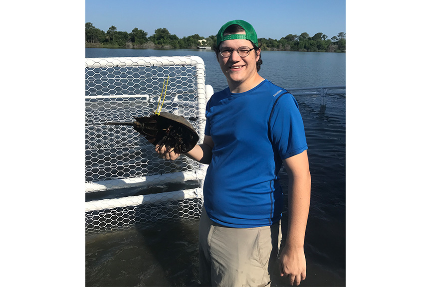 Cole Wilder, UGA Marine Extension intern, poses with a horseshoe crab.
